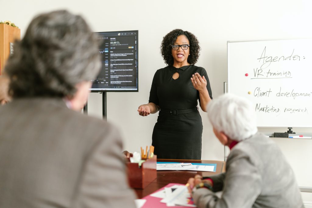A black woman presenting to executives 